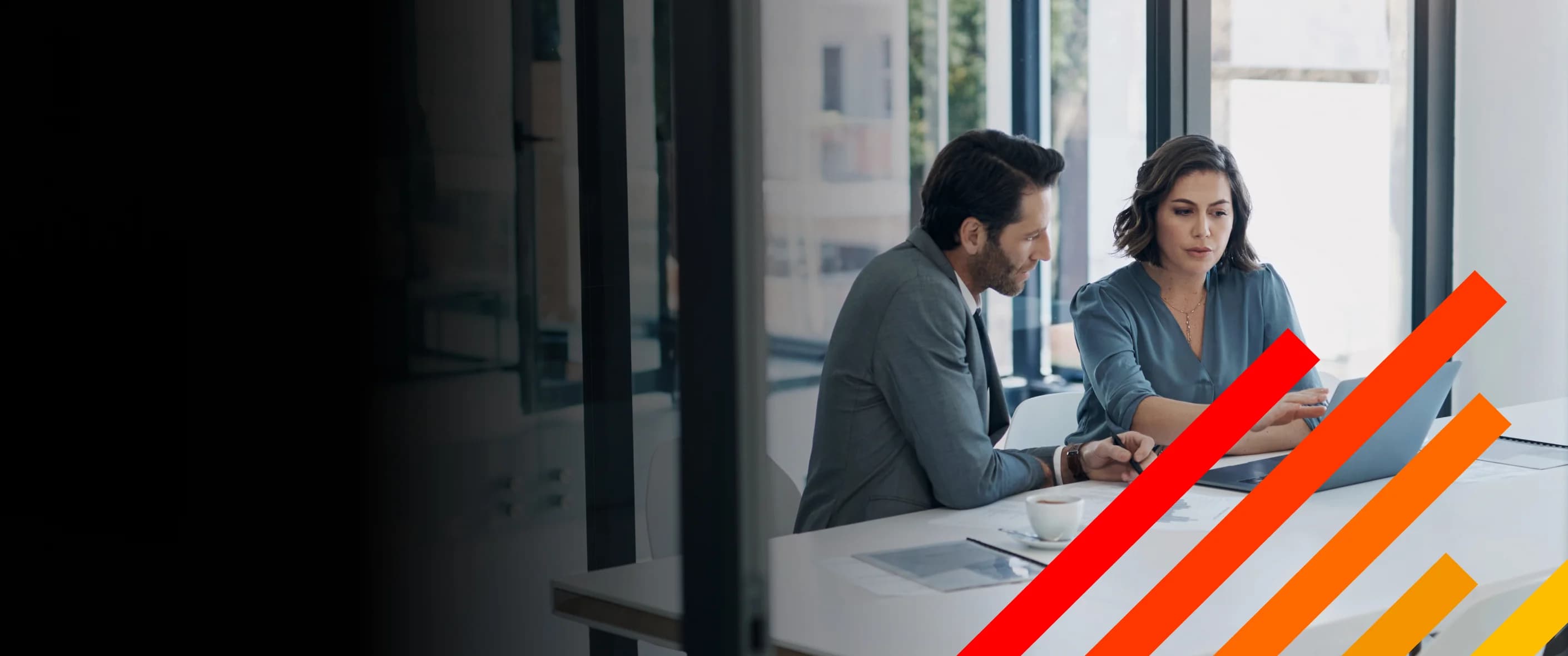 Legal experts consulting in a conference table with woman gesturing towards a laptop